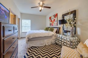 Stillwater apartment for rent - a bedroom with a bed and a dresser and a ceiling fan