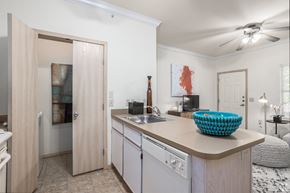 Yukon apartment for rent - a kitchen with an island and a sink and a door to a living room