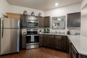 Fayetteville apartment for rent - a kitchen with stainless steel appliances and wooden cabinets