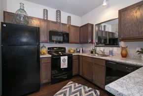 Springfield apartment for rent - a kitchen with black appliances and wooden cabinets