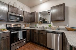 Springdale apartment for rent - A kitchen with dark wood cabinets and stainless steel appliances.