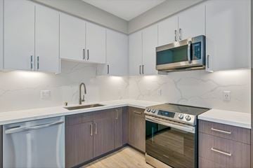 San Diego apartment for rent - A modern kitchen with a stainless steel oven and white cabinets.