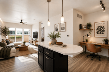 San Diego apartment for rent - A modern kitchen with a large island and a dining area with a table and chairs.