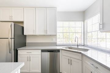 San Diego apartment for rent - A kitchen with white cabinets and a black refrigerator.