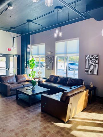 Kansas City apartment for rent - A living room with brown leather couches and a glass coffee table.