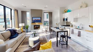 Quincy apartment for rent - A modern living room with a grey sofa and a television.
