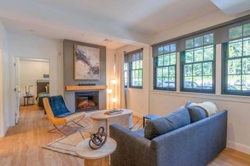 Weymouth apartment for rent - A living room with a fireplace, a blue couch, and a painting on the wall.