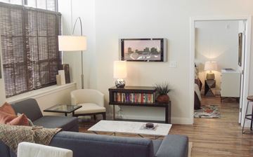 Middleboro apartment for rent - A living room with a grey couch and a painting on the wall.
