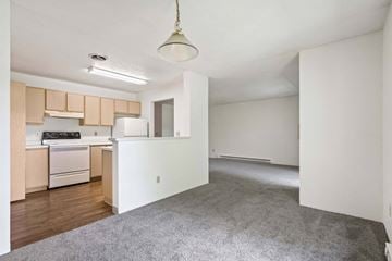 Spokane Valley apartment for rent - A kitchen with a white refrigerator and wooden cabinets.