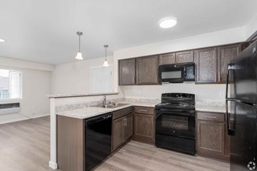 Spokane apartment for rent - A kitchen with black appliances and wooden cabinets.