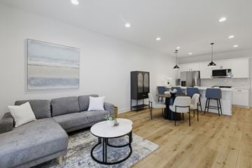 Lafayatte apartment for rent - A modern living room with a grey sofa and a painting of a beach scene on the wall.