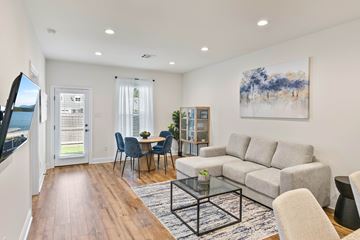Baton Rouge apartment for rent - A living room with a grey couch, a glass coffee table, and a painting on the wall.