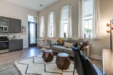Columbus apartment for rent - A modern living room with a grey sofa, a wooden coffee table, and a rug with a geometric design.