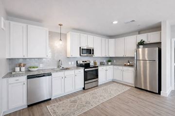 Columbus apartment for rent - A modern kitchen with white cabinets and stainless steel appliances.