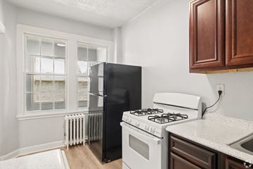 Washington apartment for rent - A black refrigerator sits next to a white stove in a kitchen.
