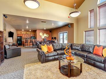 Colorado Springs apartment for rent - A living room with a black leather couch and a coffee table.