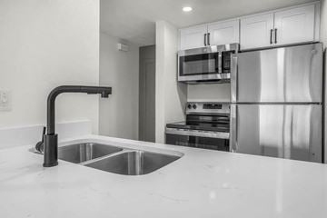 Provo apartment for rent - A modern kitchen with a sink and stainless steel appliances.