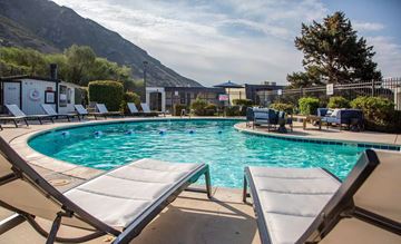 Provo apartment for rent - A pool with sun loungers and a mountain in the background.