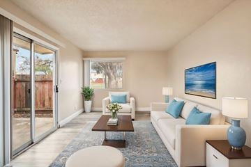 Sacramento townhouse for rent - A living room with a white couch, a coffee table, and a painting on the wall.