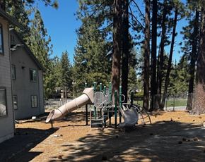 South Lake Tahoe apartment for rent - A playground with a slide and swings in a residential area.