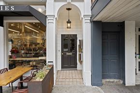 San Francisco apartment for rent - A storefront with a black door and a hanging light fixture.