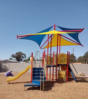 Las Vegas apartment for rent - A playground with a blue and yellow umbrella and a yellow slide.