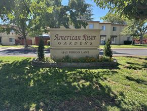 Sacramento townhouse for rent - A sign for American River Gardens stands in front of a building.
