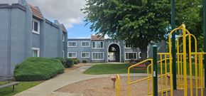 Marysville apartment for rent - A playground with a yellow slide in front of a grey building.