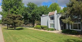 Marysville apartment for rent - A grey multifamily housing building with a green lawn in front.