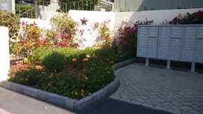 San Diego apartment for rent - a garden with lockers and flowers next to a sidewalk