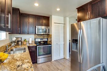 A kitchen with stainless steel appliances and granite counter tops