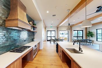 A modern kitchen with wooden cabinets and a green backsplash.