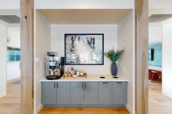 A kitchen with a large painting hanging above the counter.