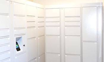 A row of white mailboxes are lined up on a wall