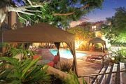 West Hollywood apartment for rent - A poolside area with a tent and chairs is lit up at night at Mediterranean Village West Hollywood, West Hollywood, 90069