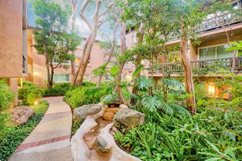 A garden with trees and rocks and a stream