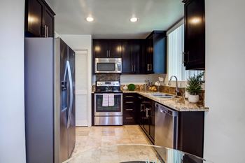A kitchen with stainless steel appliances and black cabinets
