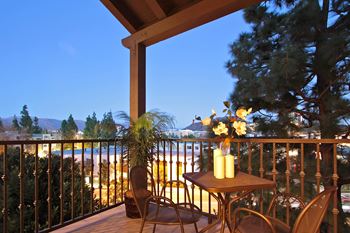 A balcony with a table and chairs and a view of the beach