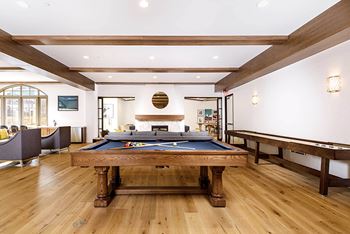 A game room with a pool table and a billiard table