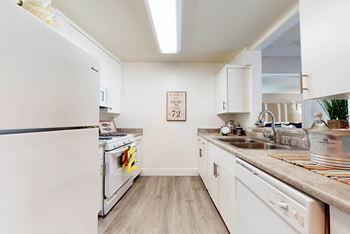 A kitchen with white appliances and white cabinets