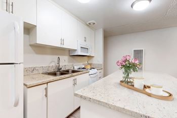 A kitchen with white cabinets and granite counter tops