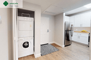A white kitchen with a washing machine and a refrigerator