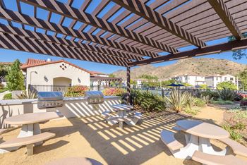 A patio with tables and chairs and a house in the background
