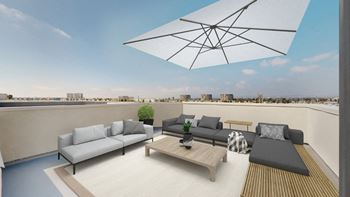 A modern outdoor patio with a large umbrella and comfortable seating.