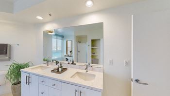 A bathroom with a double sink vanity and a large mirror.