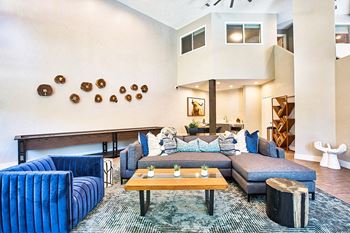 A living room with a blue couch and a wooden coffee table.