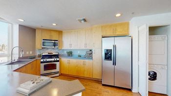 A modern kitchen with wooden cabinets and stainless steel appliances.