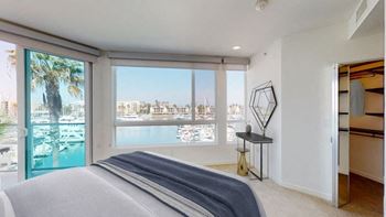 A bedroom with a large bed and a view of the city.