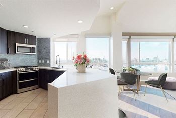 A modern kitchen with a large island and a view of the city.