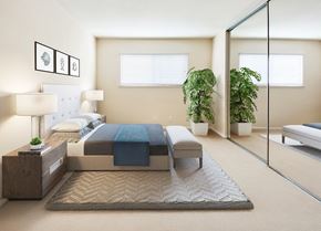 Pleasanton apartment for rent - A bedroom with a bed, nightstand, and potted plants at Pleasanton Place, Pleasanton, CA, 94566